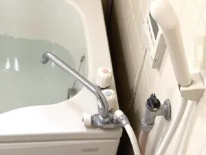 浴室の水漏れ箇所を点検する作業スタッフ