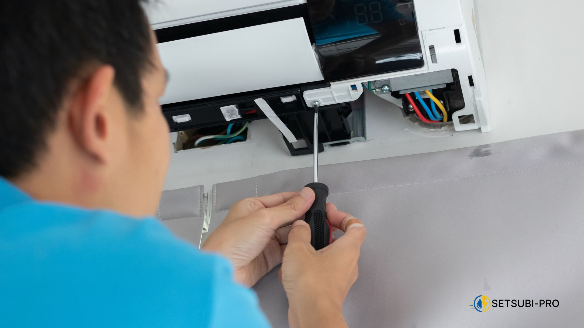 エアコンを点検する作業員