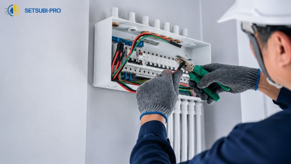 分電盤を点検する電気工事士