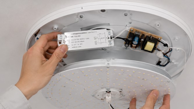 LED照明の電源ユニットを点検している様子
